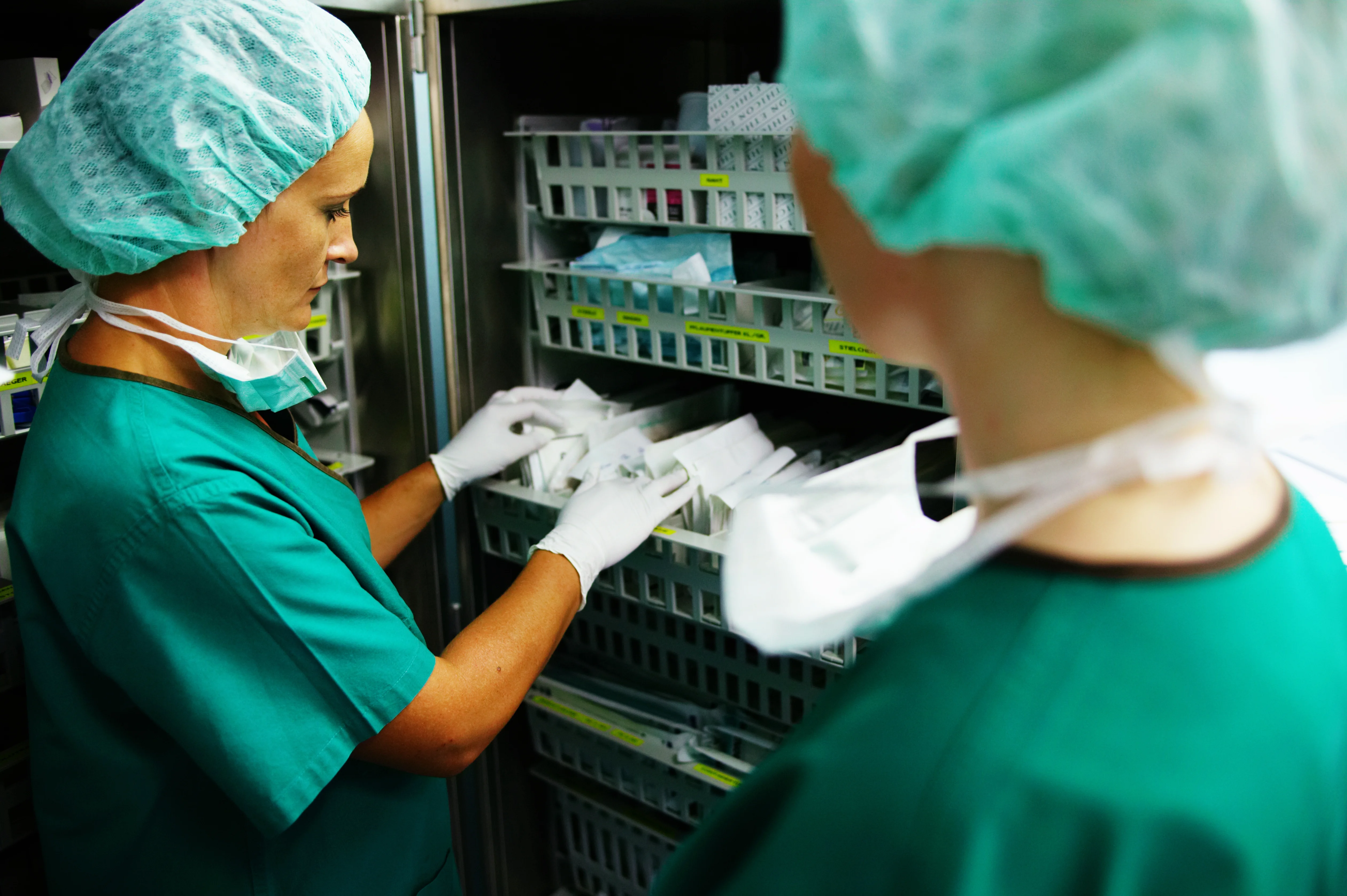 ein paar Frauen in OP-Kitteln, die in einem Raum arbeiten